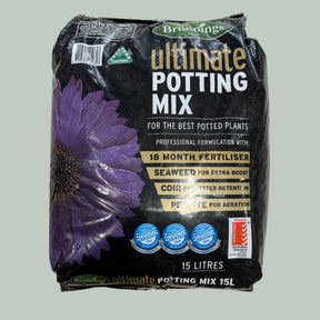 A 15-liter bag of Bruggings Ultimate Potting Mix, featuring a black background with a large purple flower graphic and gold and white text, placed on a light-colored tiled floor.